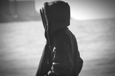 Side view of senior woman standing against sky