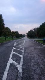 Road by trees against sky