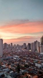 Skyscrapers in city at sunset