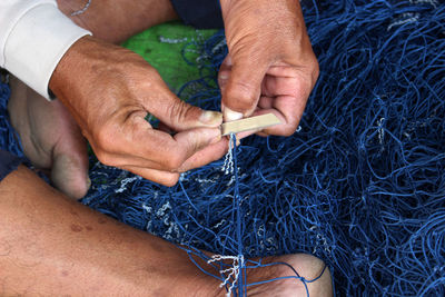 Low section of man holding fishing net