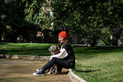 Woman sitting in park with dog