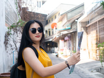 Young woman wearing sunglasses standing outdoors