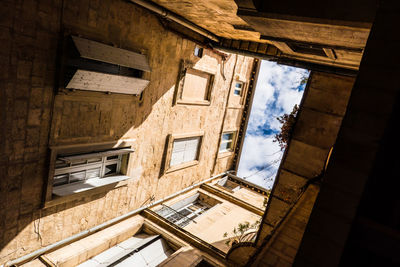 Glimpse of sky seen from a square courtyard of a building in a city in the south of france