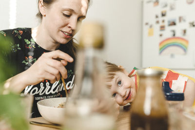 Portrait of mother and son on table at home