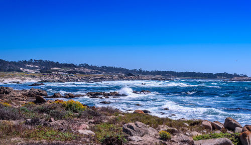 Scenic view of sea against clear blue sky