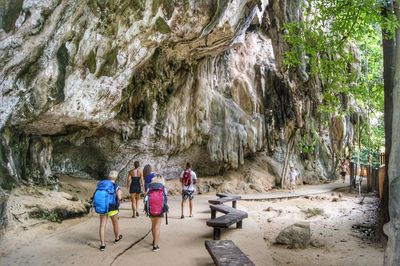 Rear view of people walking on rocks