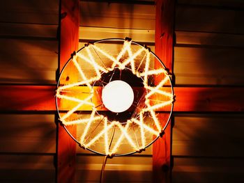 Directly below shot of illuminated lamp against orange wall