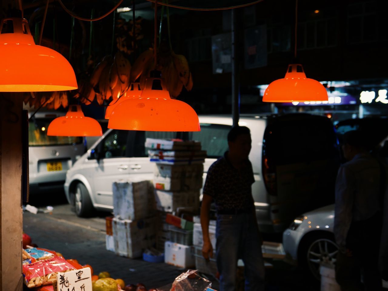 mode of transportation, transportation, motor vehicle, car, city, street, real people, land vehicle, men, orange color, architecture, road, people, group of people, standing, occupation, illuminated, incidental people, city street, focus on foreground