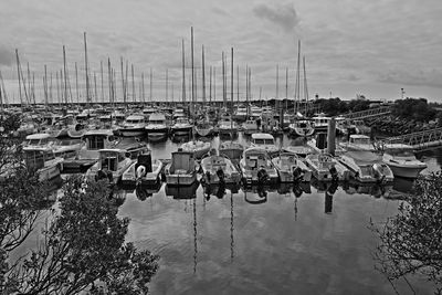 Boats moored at harbor against sky