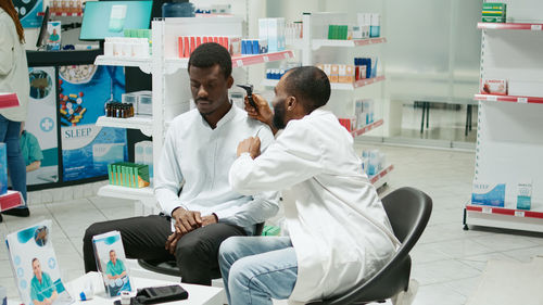 Midsection of doctor examining patient in office