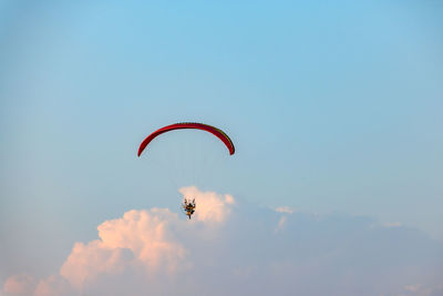 Low angle view of person paragliding against sky