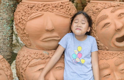 Funny girl showing cry or sad emotion near clay pots, emotion concept