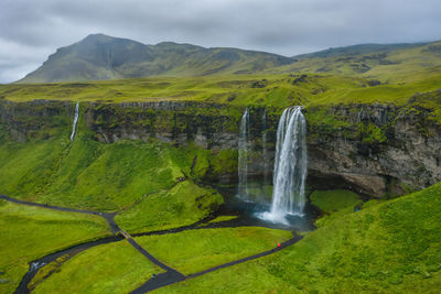 Scenic view of waterfall against sky