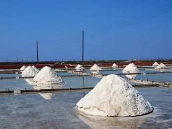 Salt heap against clear blue sky
