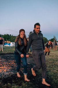 Couple holding hands while walking on hot coal