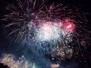 Low angle view of firework display at night