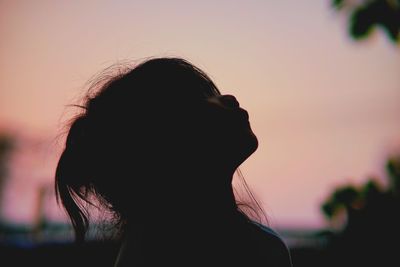 Close-up of woman looking away against sky