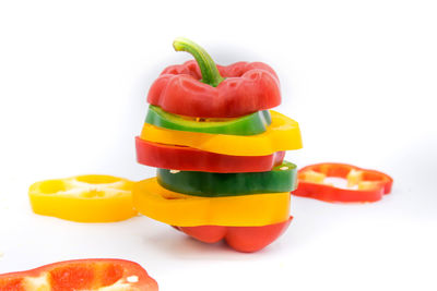 Close-up of multi colored bell peppers against white background