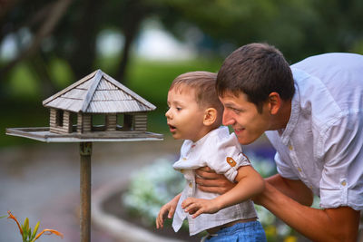 Father with son looking in birdhouse
