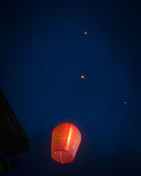 Low angle view of illuminated lantern against sky at night