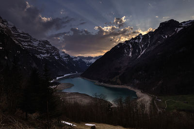 Scenic view of lake by snowcapped mountains against sky