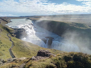 Scenic view of waterfall against sky