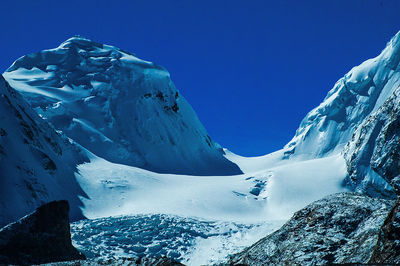 Scenic view of snowcapped mountains against clear blue sky