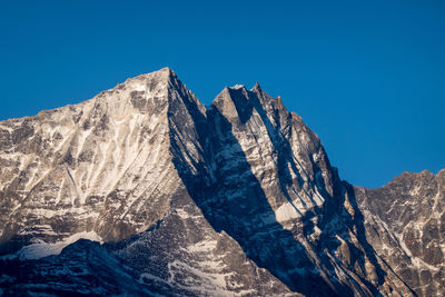 Scenic view of snowcapped mountains against clear blue sky