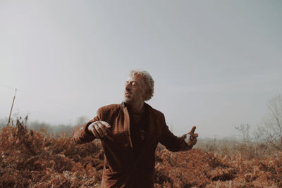Man standing on field against sky