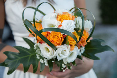 Midsection of bride holding bouquet during wedding
