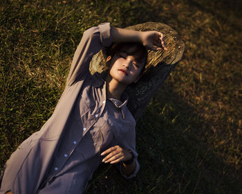 Portrait of a young woman lying on field