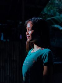 Side view of teenage girl standing outdoors