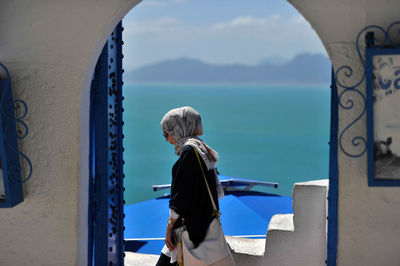 Rear view of woman looking at sea against sky