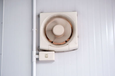 Close-up of electric lamp on white wall