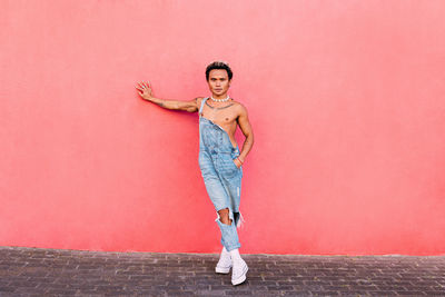 Portrait of young man against pink wall