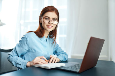 Portrait of smiling woman using mobile phone