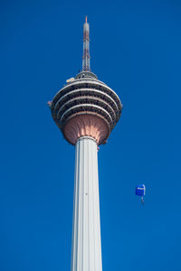 Low angle view of communications tower against blue sky