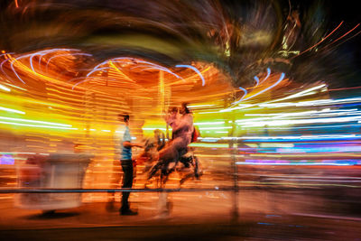 Full length of man with light trails in city at night