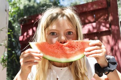 Portrait of girl eating watermelon outdoors