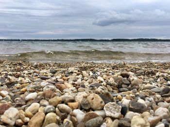 Surface level of pebbles at beach against sky