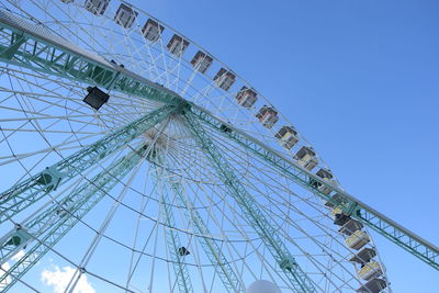 Low angle view of ferris wheel against clear blue sky