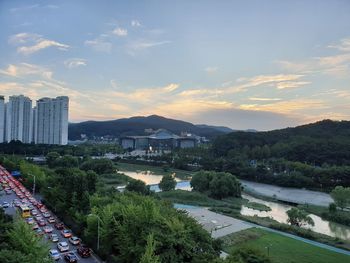 Scenic view of river by buildings in city against sky