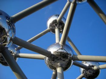 Low angle view of metallic structure against blue sky