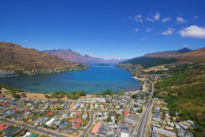 High angle view of sea and mountains against blue sky