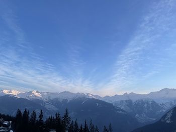 Scenic view of snowcapped mountains against blue sky