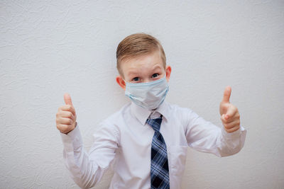 Portrait of boy standing against wall