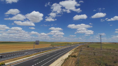 View of field against cloudy sky