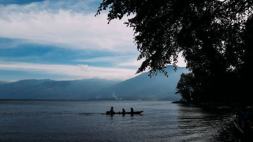 Silhouette people on beach against sky