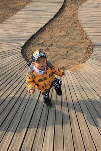 High angle view of boy playing on wood