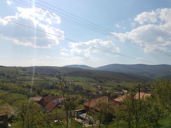 Scenic view of landscape and houses against sky